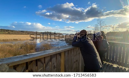 People birdwatching with binoculars in a tower Royalty-Free Stock Photo #1713456583