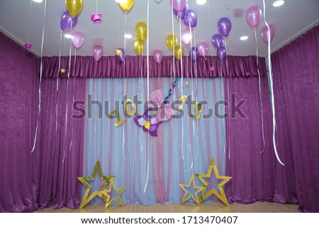 Pink and yellow balloons float on the white ceiling in the room for the party. Wedding or children birthday party decoration interior . Helium balloons .