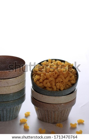 Raw Macaroni in a Rustic Bowl Isolated Images with White Background