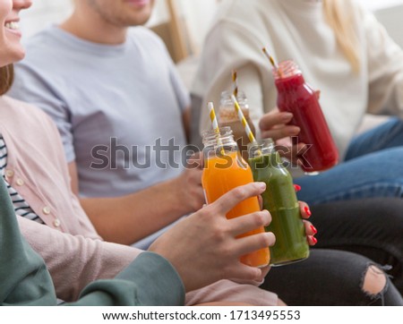 Modern friends drinking colored healthy detox smoothie at home, healthy party