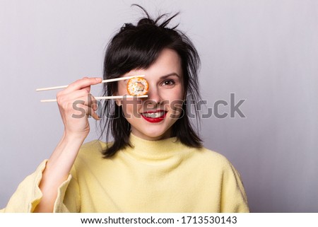 Woman with food in her hands. Sushi on sticks