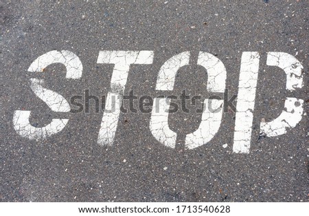 Word Stop written on an asphalt road, Stop Sign
