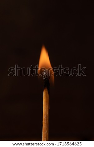 Burning safety match with dark background