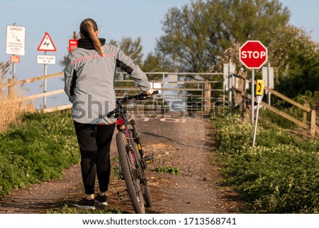 Young woman with bike crossing rail line