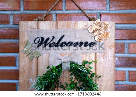 Wooden sign reads "Welcome" on a wooden door in front of a coffee shop in vintage style