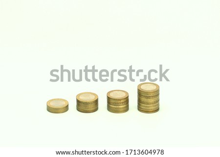Piles of golden metallic coins. Columns of coins of different heights. The concept of business, economy, finance, investment and prices. Place for text and background for design.