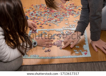Mother and daughter playing with a jigsaw on the floor of the home due to the confinement of cornavirus covid-19 Royalty-Free Stock Photo #1713617317