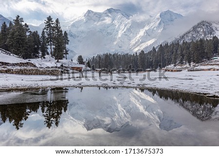 Nanga parbat mountain reflection in lake on Fairy meadows valley beautiful winter snowy landscape Karakoram Pakistan Royalty-Free Stock Photo #1713675373