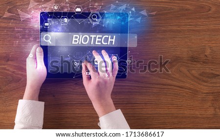 Close-up of a tablet searching BIOTECH inscription, hi-tech computing concept