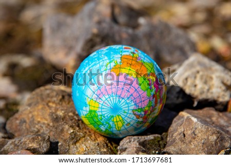 Globe on rocks on a blurry background. The concept of preservation of the environment.
