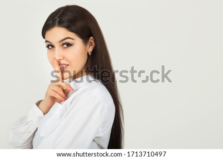 beautiful young woman in a white shirt on a white background with hand gesture	
