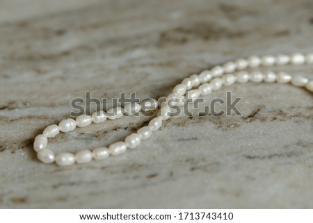 white pearl necklace on marble table background