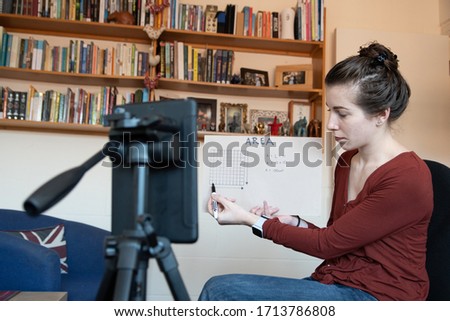 School teachers are forced to teach their lessons from home using their phones to video themselves Royalty-Free Stock Photo #1713786808