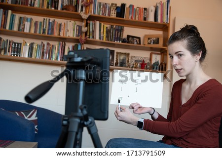 School teachers are forced to teach their lessons from home using their phones to video themselves under covid-19 coronavirus rules Royalty-Free Stock Photo #1713791509