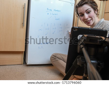 School teachers are forced to teach their lessons from home using their phones to video themselves under covid-19 coronavirus rules Royalty-Free Stock Photo #1713796060
