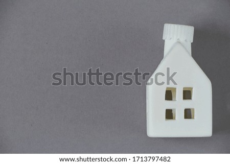 Stay home concept, toy white house figurine on gray background, quarantine background