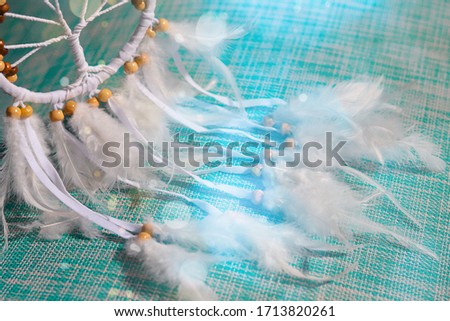 
dream catcher on a turquoise background with bokeh