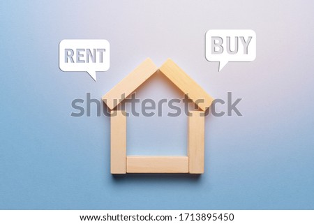 Concept of renting or buying real estate house made of wooden blocks with icons. Close up.