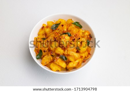 Cooked tapioca or Cassava with  spicy meat curry, beef with tapioca, Kerala  India.Root vegetable Mandioca or Aipim staple food Brazil. Top view South Indian food on white background.