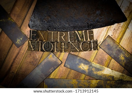 Photo of real authentic typeset letters forming Extreme Violence text in online game context on vintage textured grunge copper and gold background with rusty axe blade overhead