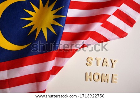 the word STAY HOME and the Malaysian flag on the white background.