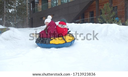 Children ride on an ice slide. Slowmotion