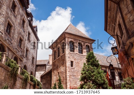 historic building in a medieval style on the background of blue sky. In the center is the tower facade of the castle