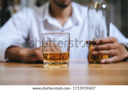 Alcoholism concept. Young man drinking alcohol too much. Royalty-Free Stock Photo #1713939607