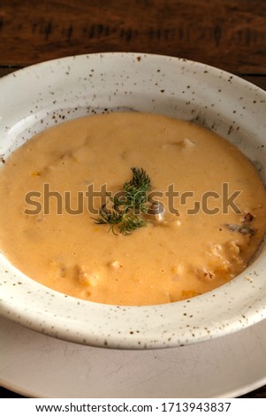 Fresh Seafood meal of Lobster bisque soup in a bowl on a white plate.