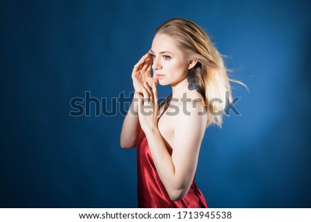  beautiful girl with healthy skin and beautiful hair poses in a Studio on a blue background
