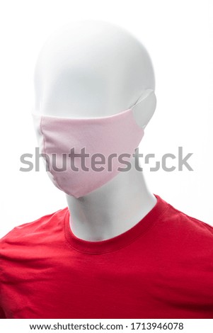 protective face mask against coronavirus on the face of a mannequin, pink color isolated on a white background
