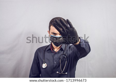 doctor makes stop sign with hands on gray background