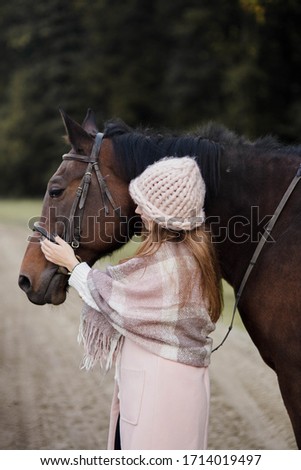Girl with a horse in the nature