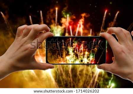 Taking the photo of fireworks via smartphone. Broadcast salute video to the internet