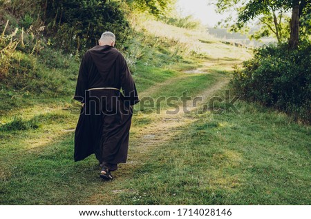 Catholic monk in robes praying in the woods. Copy space Royalty-Free Stock Photo #1714028146
