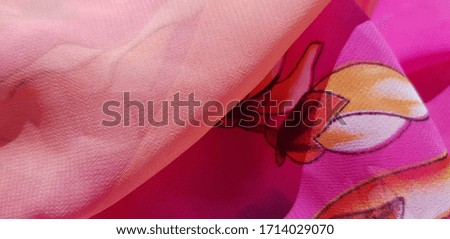 Pink, semi-transparent women's shawl with a floral print of orchids (diagonal fold,texture).
