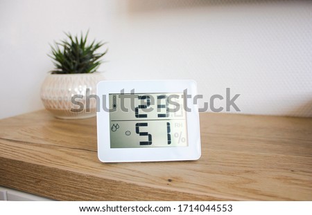 Thermometer hygrometer measuring the optimum temperature and humidity in a house, apartment or office, a photo for articles about the house’s microclimate, health, disease relief and virus treatment Royalty-Free Stock Photo #1714044553