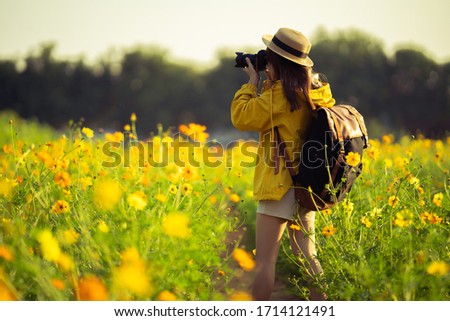 Female tourists she is taking pictures with the camera at the flower field