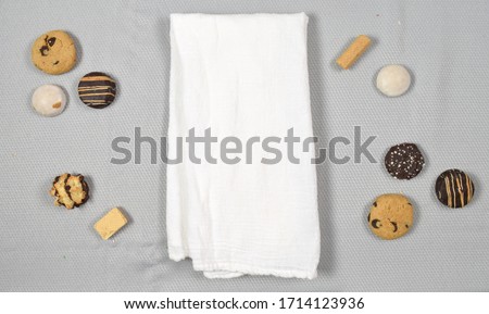 Top down view of white tea towel surrounded by delicious cookies.