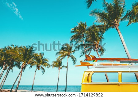 vintage car parked at the tropical beach (seaside) with a surfboard on the roof - Leisure trip in the summer. retro color effect Royalty-Free Stock Photo #1714129852