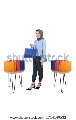 Photo of beautiful women of Muslim Indonesia is holding a shopping bag with a smile expression isolated on white background