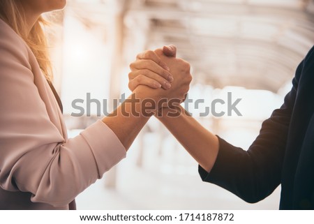 Business partnership meeting trust handshaking concept. Businesswomen doing arm wrestling. Successful business people contract promise for good confidence dealing with skyscraper building background