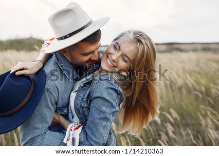 Loving couple in a wheat field. Beautiful blonde in a blue hat. Royalty-Free Stock Photo #1714210363