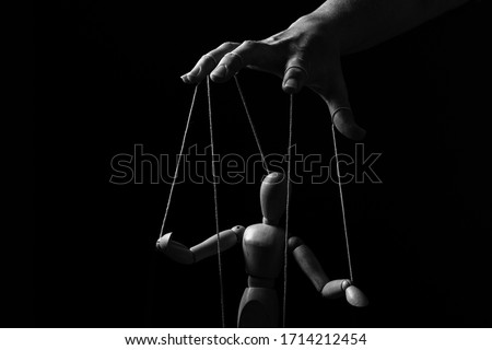 Conceptual image of a hand with strings on fingers to control a marionette in monochrome Royalty-Free Stock Photo #1714212454