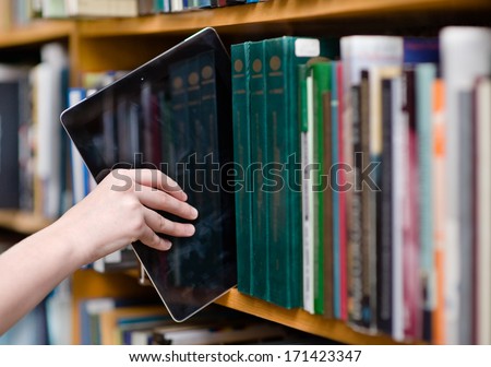 closeup hand putting a tablet pc in the shelves in the library Royalty-Free Stock Photo #171423347