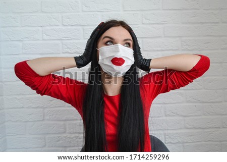 Home beauty industry because of the coronavirus pandemic. A beautiful girl in a protective mask and gloves stays at home and make beauty procedures. Girl with red lips and manicure