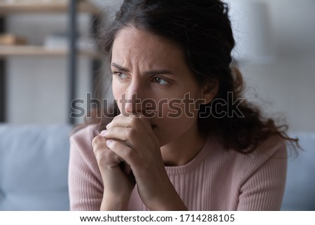 Close up head shot frustrated stressed young woman thinking of difficult decision, suffering from psychological trauma alone in living room. Thoughtful millennial girl worrying about health problems. Royalty-Free Stock Photo #1714288105