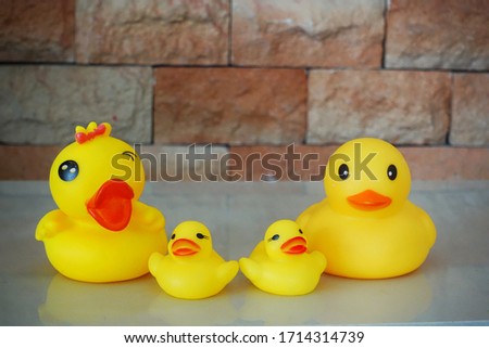 DUCK toys conceptual photo to show happy family concept. Brick wall background 