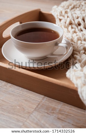 white cup of tea on dotted serving plate. Cup of tea on white marble background. Flat lay with copy space.