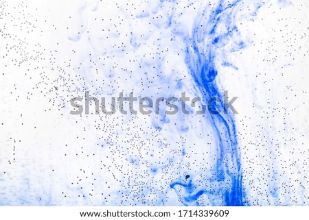 air bubbles on glass surface of flat bottle and blue ink flow in water on background